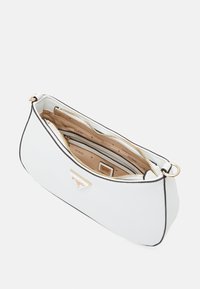 Bolso blanco con acabado texturizado, cremallera dorada y ribete negro. El interior cuenta con múltiples compartimentos y un detalle del logo de la marca.