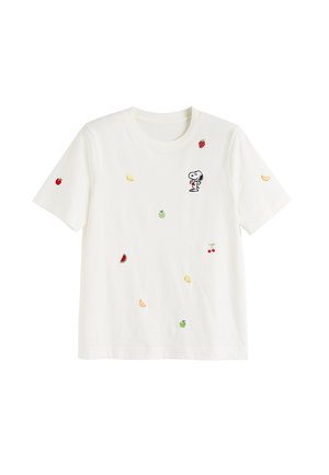 T-shirt bianca a maniche corte con piccoli frutti ricamati e un cartone animato di Snoopy che tiene un cuore rosso sul petto.