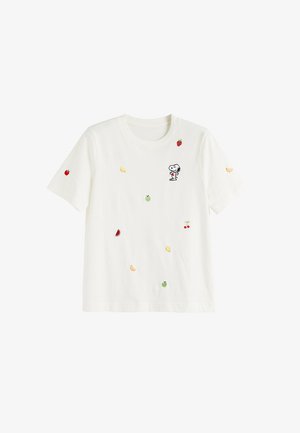 T-shirt bianca a maniche corte con piccoli frutti ricamati e un cartone animato di Snoopy che tiene un cuore rosso sul petto.