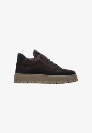 Bruine suède sneakers met zwarte accenten, ronde neus, platte rubberen zool en vetersluiting met zes oogjes. Getextureerde details op de zool.