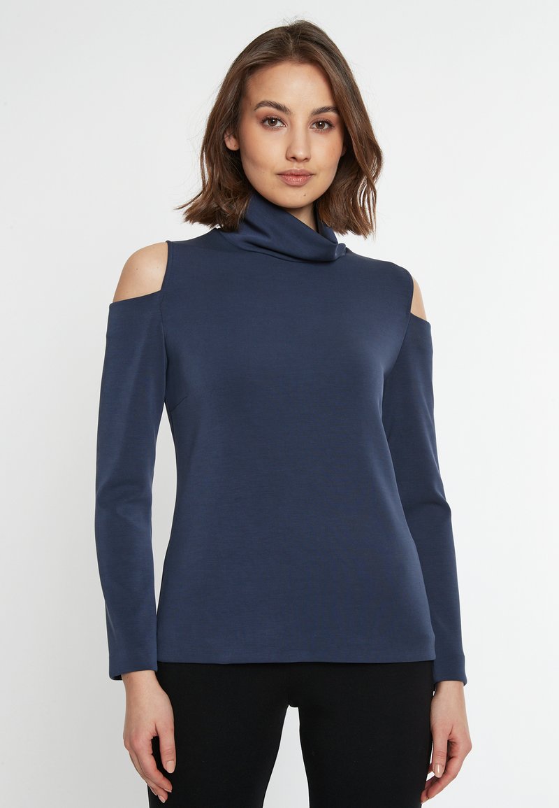 Dunkelblaues Rollkragenoberteil mit Cutouts an den Schultern, langen Ärmeln und einer glatten Stofftextur. Enganliegendes Design.