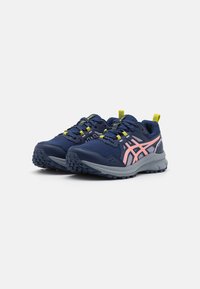 Zapatillas deportivas para hombre con parte superior de malla en navy, acentos en rosa, cordones amarillos y una suela de goma texturizada para mayor agarre. Presenta una entresuela acolchada.