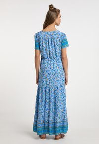 Abito lungo in tessuto blu chiaro, con stampa floreale, maniche corte con bordo decorato e gonna a balze.