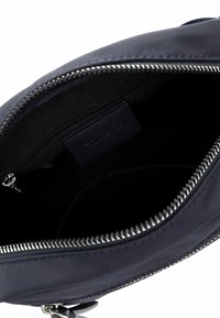 Navy fabric bag interior, featuring a zip closure and a small zipped pocket. Smooth texture with silver hardware accents along the zipper.