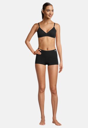 Black sports bra with adjustable straps and a smooth, seamless design paired with black hipster shorts, both made of soft, stretchy fabric.