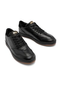 Baskets en cuir noir à finition lisse, design à lacets et semelle en caoutchouc marron. Dotées du logo "RKO" sur la languette et de surpiqûres discrètes.