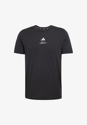 Black t-shirt made of soft fabric, featuring a crew neck, short sleeves, and a white "LES MILLS" logo on the chest with Adidas branding.