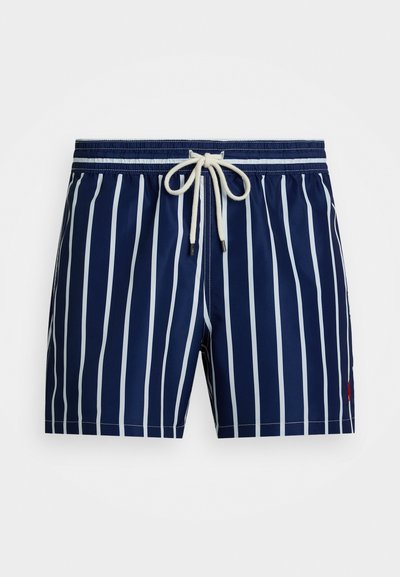 Ναυτικά μαγιό με λευκές κάθετες ρίγες, ελαστική μέση, κορδόνι και μικρό κόκκινο λογότυπο στο κάτω δεξί μέρος. Λείος υφασμάτινος σχεδιασμός.