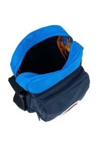 Bolsa de tela de color azul marino con una solapa acolchada azul y un interior dorado. Cuenta con un bolsillo frontal con cremallera y una correa de hombro desmontable.