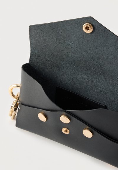 Μαύρο δερμάτινο πορτοφόλι ανοιχτό που δείχνει το σκοτεινό εσωτερικό, ασφαλισμένο με τρία χρυσά κουμπώματα και με χρυσό κρίκο για κλειδιά.