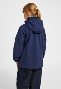 Marinblå huvjacka med avslappnad passform, elastiska ärmslut och en mjuk textur. Bakifrån syns ingen synlig hårdvara eller detaljer.