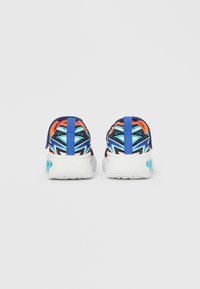 Pantofi sport cu partea superioară albastră și geometrică multicoloră, talpă albă și accente portocalii contrastante. Dispune de o buclă pentru a fi ușor de încălțat.