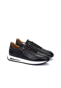 Zwarte leren sneakers met een witte rubberen zool, ronde neus en vetersluiting. Heeft een tan interieur en een subtiel logo op de zijkant.