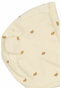Cappello di cotone color beige chiaro con piccole stampe a forma di cuore dorato, caratterizzato da un design arrotondato e un bordo ondulato lungo la cucitura.
