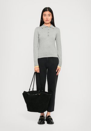Gray long-sleeve polo with three buttons, yellow collar accents, black high-waisted jeans, and a large black suede tote bag. Black loafers.
