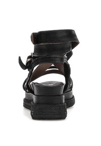 Černé kožené sandály s několika pásky, zakulaceným podpatkem, texturovaným povrchem a nastavitelným detailem na kotníku.