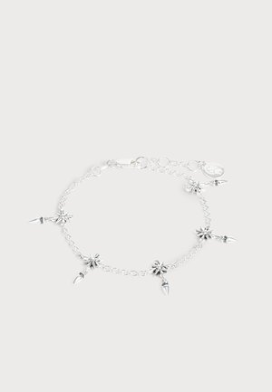 Bracelet chaîne en argent avec cinq breloques en forme d'étoile, chacune avec un petit pendentif pointu, présenté sur un fond clair.