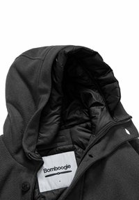 Giacca nera con cappuccio, caratterizzata da un esterno strutturato e una fodera liscia, con chiusura a zip e un'etichetta visibile all'interno del colletto.