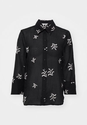 Juodas mygtukų užsegimas marškinis, pagamintas iš lengvos medžiagos, su baltais išsiuvinėtais gėlių raštais ir klasikiniu apykakle. Ilgos rankovės su rankogalių detalėmis.