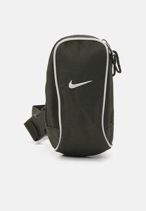 Lille mørkegrøn Nike-pung med hvidt logo og kant, lynlås i toppen og justerbar rem med plastikspænde.