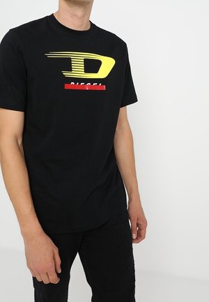 T-shirt en coton noir avec un logo graphique jaune et rouge. Manches courtes et col rond pour une coupe décontractée.