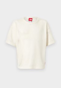 T-shirt blanc à manches courtes en maille avec col rond et étiquette logo rouge au niveau du col et de l'ourlet sur un fond uni.