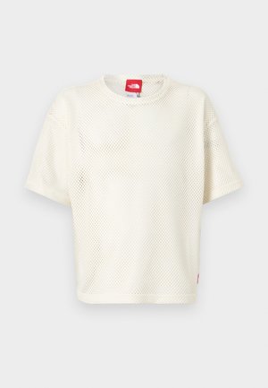 T-shirt blanc à manches courtes en maille avec col rond et étiquette logo rouge au niveau du col et de l'ourlet sur un fond uni.