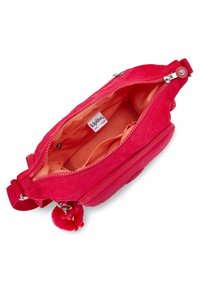 Red fabric bag with a main zip compartment, orange lining, and small exterior pom-pom detail. Features multiple zippered pockets.