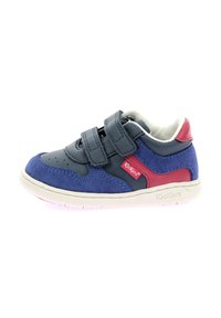 Sneaker en cuir bleu et marine avec deux bandes Velcro, accent rouge, semelle en caoutchouc blanche et détails perforés sur les orteils.