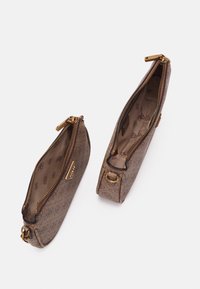 Brązowa torba z teksturowanej tkaniny z złotymi elementami, zamkiem błyskawicznym i wzorem wewnątrz. Posiada dwie zamykane na suwak kieszenie i boczne pierścieniowe uchwyty.