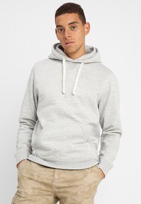 Light gray hoodie made of soft, textured fabric; features a drawstring hood, front pocket, and ribbed cuffs and hem.