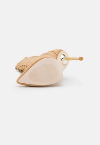 Chaussure à talons hauts beige avec une semelle texturée, un bout pointu et un accent doré sur le capuchon du talon. Tige en cuir lisse avec coutures décoratives.