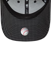 Čierny a sivý károvaný baseballový klobúk s okrúhlou nálepkou lopty na vnútornej strane čela. Tkanina má hladkú štruktúru.