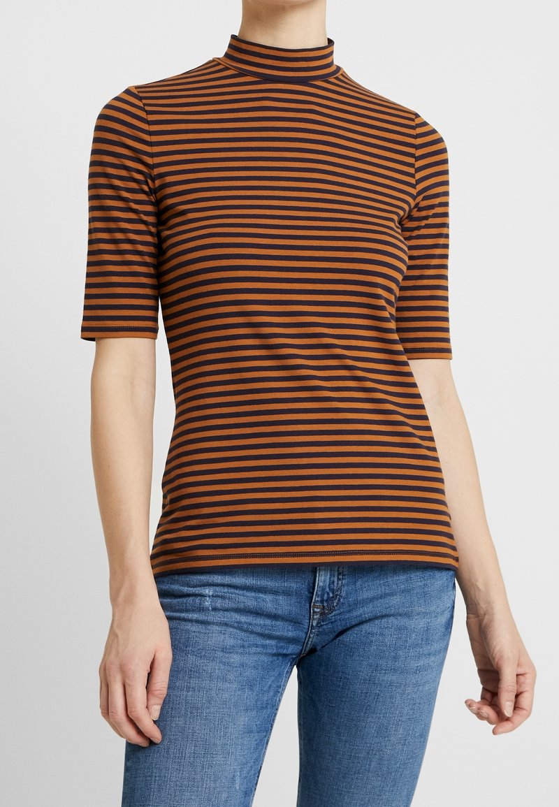 Camisa de rayas con cuello alto, con rayas horizontales en marrón y azul marino. Mangas cortas y un diseño ajustado.
