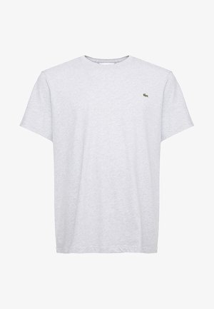 Camiseta de algodón gris con mangas cortas, cuello redondo y pequeño logo verde en el lado izquierdo del pecho. Textura suave y un corte clásico.