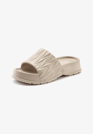 Beige slide sandal with a textured, quilted upper and open toe design. Flat sole features grooves for traction. Made from durable material.