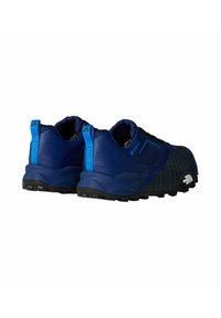 Zapatos exteriores azules con malla texturizada y parte superior sintética. Presentan suela de goma negra, cordones y una lengüeta trasera para facilitar su uso.