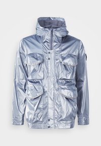 Silver waterproof jacket with a zip closure, adjustable hood, and four front pockets. Features a shiny texture and snap fasteners.