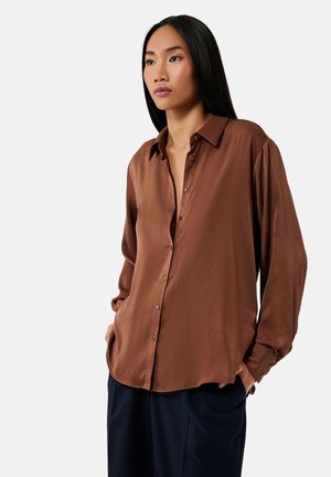 Bruine satijnen blouse met lange mouwen, knoopsluiting aan de voorkant, losse pasvorm en één borstzak. Heeft een klassieke kraag en knopen bij de manchetten.