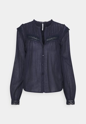 Dark navy blue long-sleeve blouse with front buttons, lace details on shoulders, cuffs, and upper chest, and a round neckline.