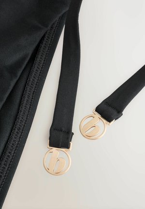 Zwarte stoffen banden met goudkleurige cirkelvormige sluiting met een gestileerd kleine letter "b" ontwerp; gladde textuur, stevige constructie.