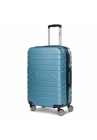 Hard-shell koffer in teal met geribbelde structuur, een uitschuifbare handgreep, zwarte accenten, ritssluiting en vier draaiwielen.