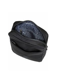 Borsa in nylon nero con superficie testurizzata, chiusura con zip e fodera interna con marchio caratterizzata da un motivo logo ripetuto. Include un taschino aggiuntivo.