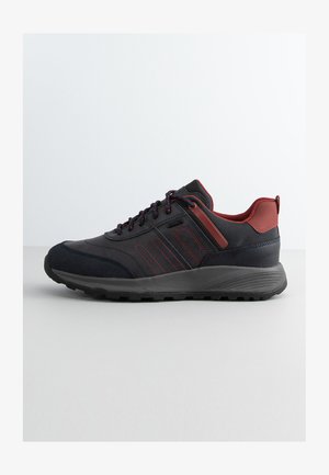 Black and dark red athletic shoe with a textured upper, thick black sole, reinforced toe, and contrasting red accents on the sides.