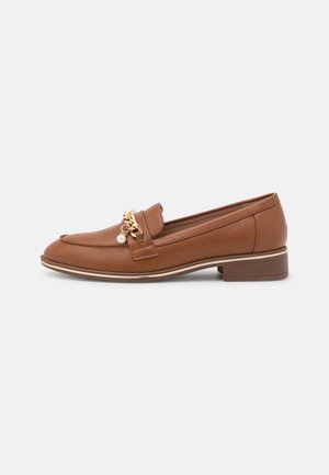 Mocassin en cuir marron avec talon bas, chaîne dorée et décoration de perle sur le dessus, présenté en profil latéral sur fond blanc.
