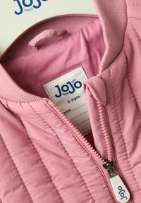 Veste matelassée rose clair avec une fermeture éclair, un col à côtes, et une étiquette indiquant la taille 2-3 ans de JoJo Maman Bébé. Texture douce.