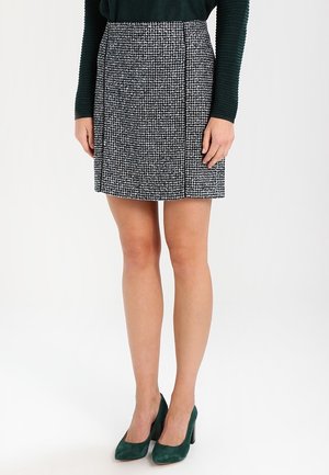 Jupe à motif pied-de-poule en noir et blanc, design structuré avec une coupe droite, tissu à finition texturée, longueur mi-cuisse.