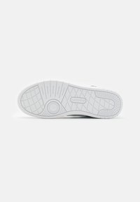 White sneaker sole with textured rubber, featuring a circular logo and a grid pattern for traction. Simple, flat design.