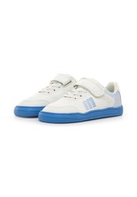 Zapatillas infantiles blancas y azules con correas de velcro, cordones y un diseño a rayas en los lados, presentadas sobre un fondo blanco.