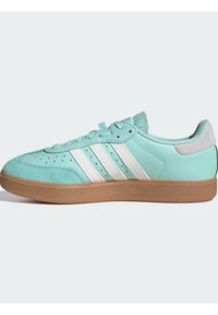 Jasnoniebieskie sneakersy z trzema białymi paskami. Posiadają gładkie skórzane wykończenie, miękki kołnierz i gumową podeszwę. Niskoprofilowy fason.